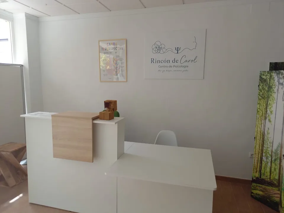 Zona de recepción del Rincón de Carol con el logotipo del centro en la pared