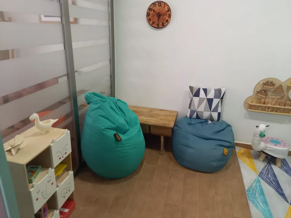 Rincón infantil con pufs, cuentos y juguetes de madera