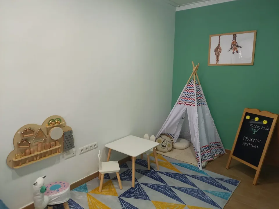 Sala de terapia infantil con tipi, panel sensorial de música y juegos